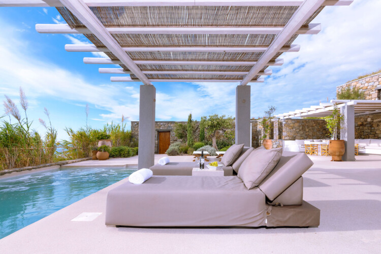 outdoor patio with private pool, sunbeds and an outdoor dining area in villa ammolite, mykonos