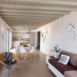 living room, kitchen and dining area with minimalistic and cozy interior design at villa ammolite in mykonos