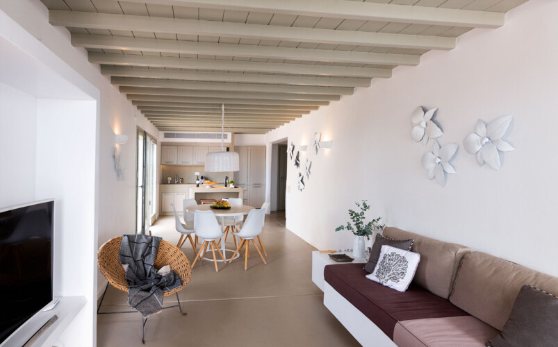 living room, kitchen and dining area with minimalistic and cozy interior design at villa ammolite in mykonos