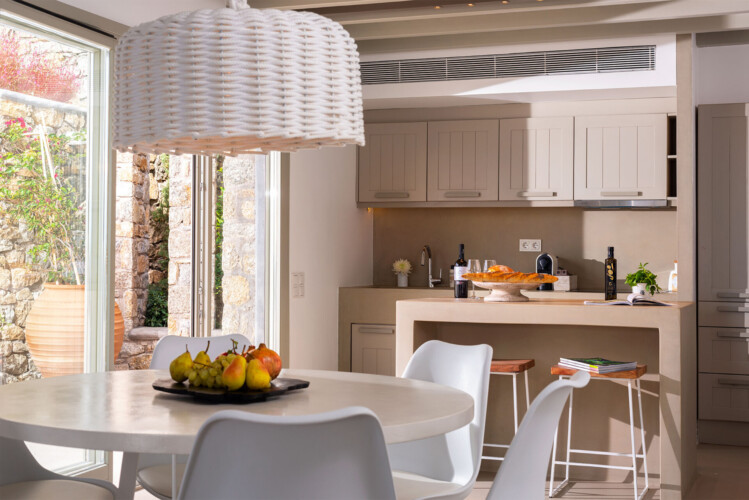 kitchen and dinning area with neutral tones and minimalistic interior design at villa ammolite in mykonos