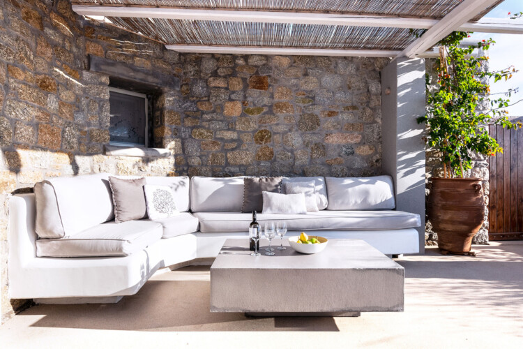 outdoor sitting area, wines and fruits on the table at villa ammolite in mykonos