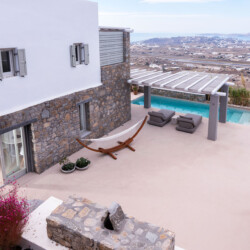 picture taken from above from villa ammolite and its terrace, with private swimming pool, dining area and sunbeds with a magnificent view from mykonos