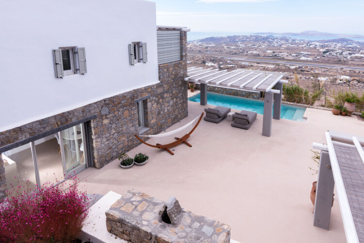 picture taken from above from villa ammolite and its terrace, with private swimming pool, dining area and sunbeds with a magnificent view from mykonos