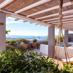 outdoor area with sunbeds, swimming pool and beautiful garden with a panoramic view from mykonos in villa ammolite