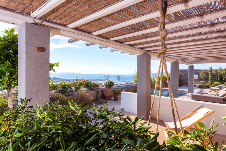 outdoor area with sunbeds, swimming pool and beautiful garden with a panoramic view from mykonos in villa ammolite